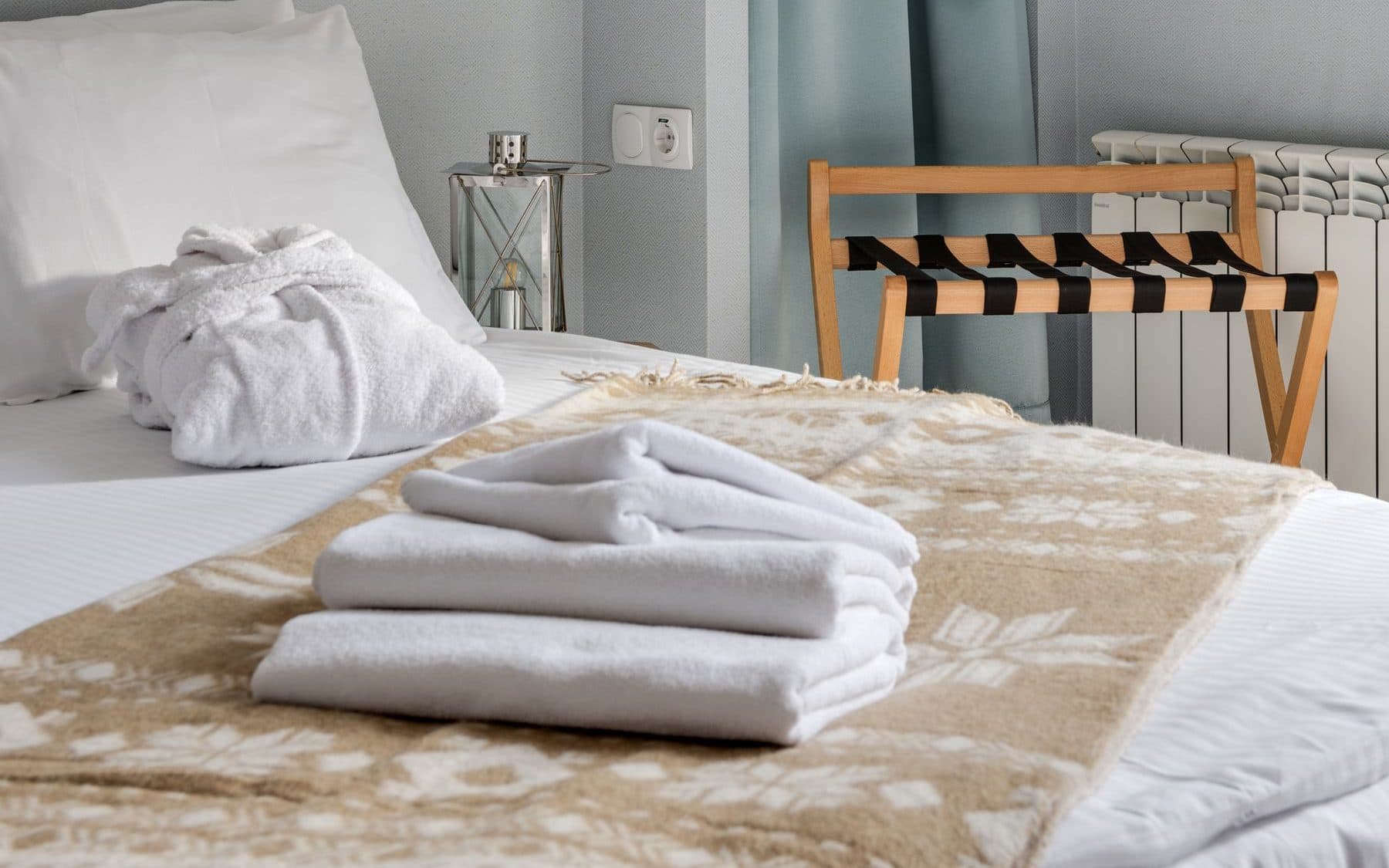 Toallas dobladas sobre una cama con luz natural